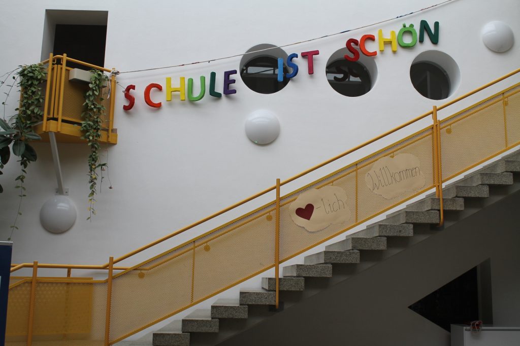 Bunte Dekoration mit Schriftzug Schule ist schön im Treppenhaus