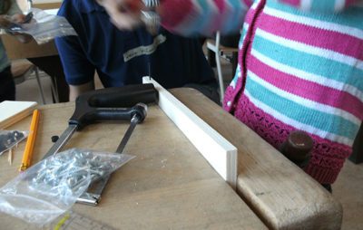 Kinder beim Holzhandwerk in der Schule mit Werkzeugen