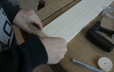 Person arbeitet an Holzprojekt auf Werkbank mit Werkzeugen