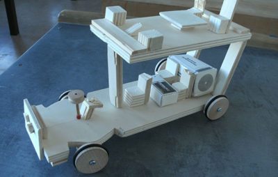 Holzspielzeugauto auf einem Tisch aus heller Holzoptik