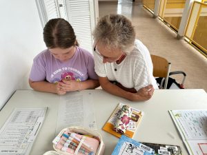 Kind bei Hausaufgabenhilfe mit einer erwachsenen Person