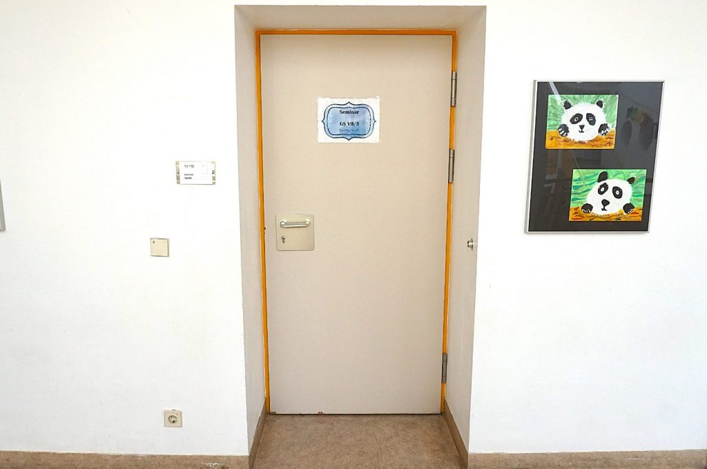 Bürotür mit Panda-Bildern an der Wand im Büroflur